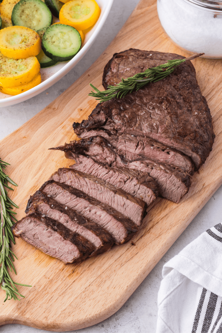 Perfectly cooked air fryer sirloin steak, golden-brown on the outside, juicy and tender inside, served with fresh herbs.
