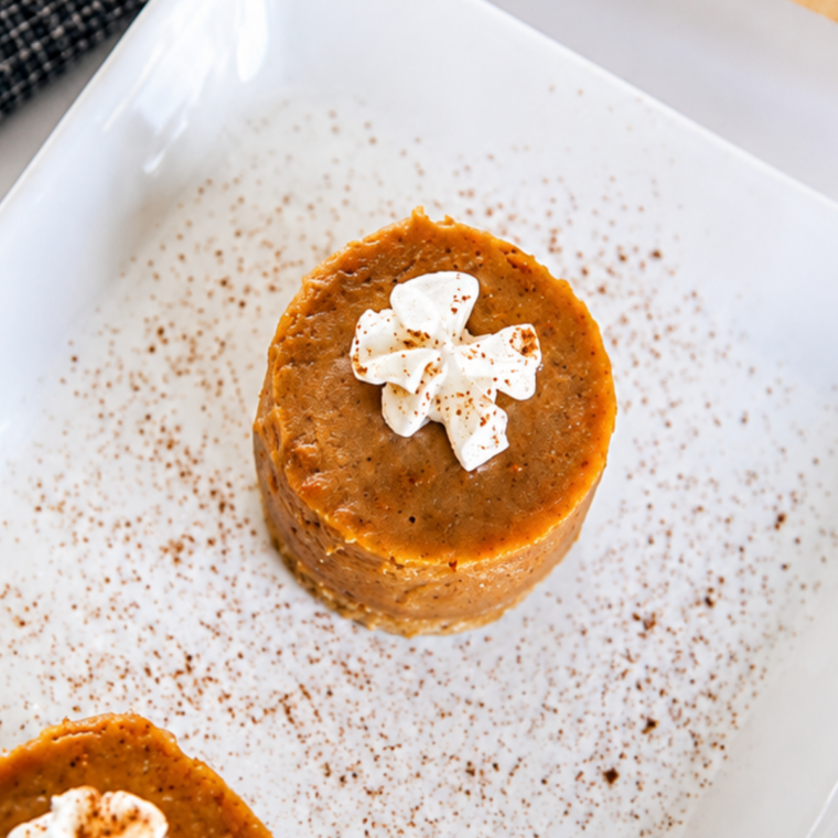 Pumpkin pie bites served on a dessert plate with toasted pecan halves on top