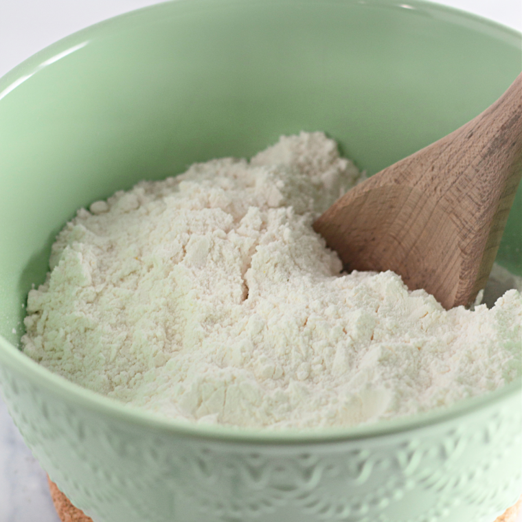 Vanilla mug cake batter being whisked smooth in a small white mixing bowl