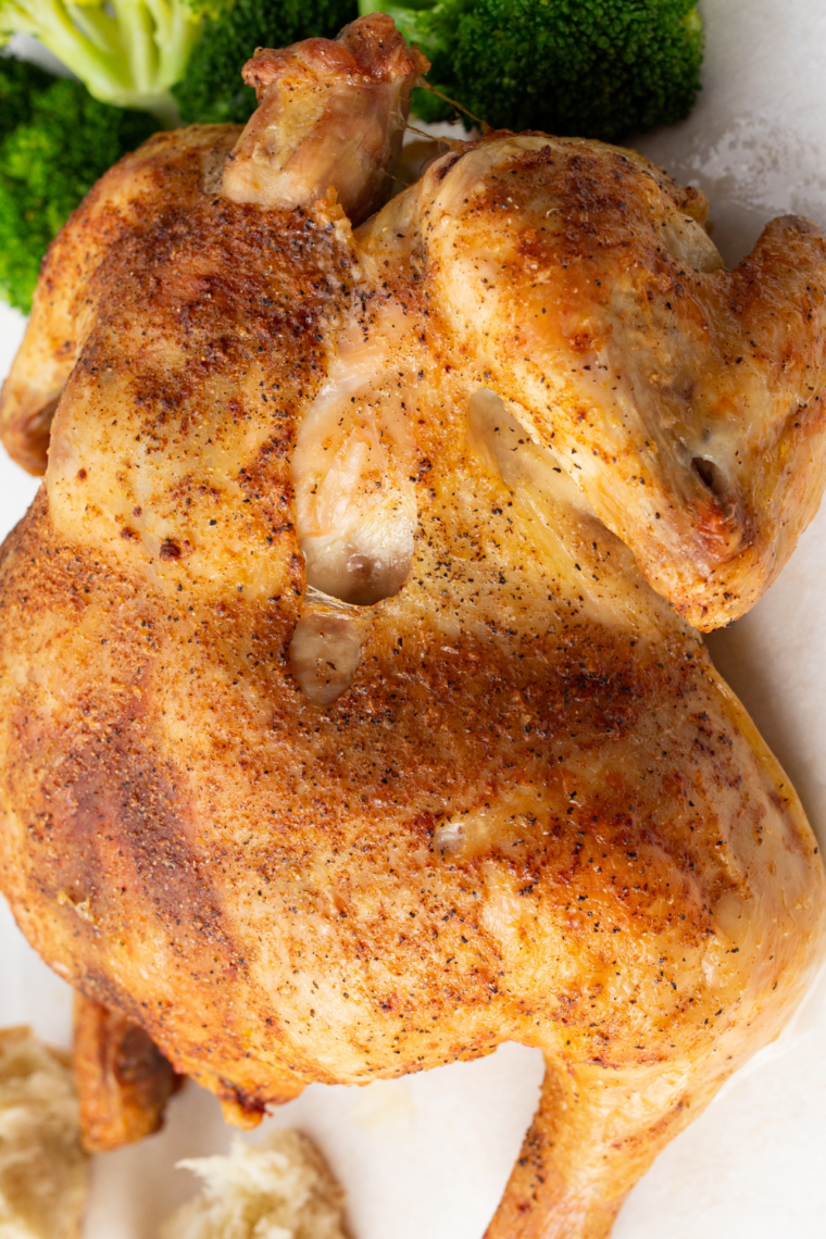 Air fryer Cornish hens with crispy golden skin resting on a serving plate