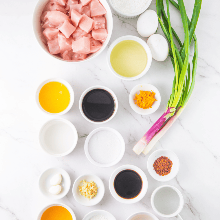 "Ingredients for slow cooker orange chicken including raw chicken, fresh oranges, soy sauce, honey, garlic, and ginger" — best default; keyword up front plus an honest description