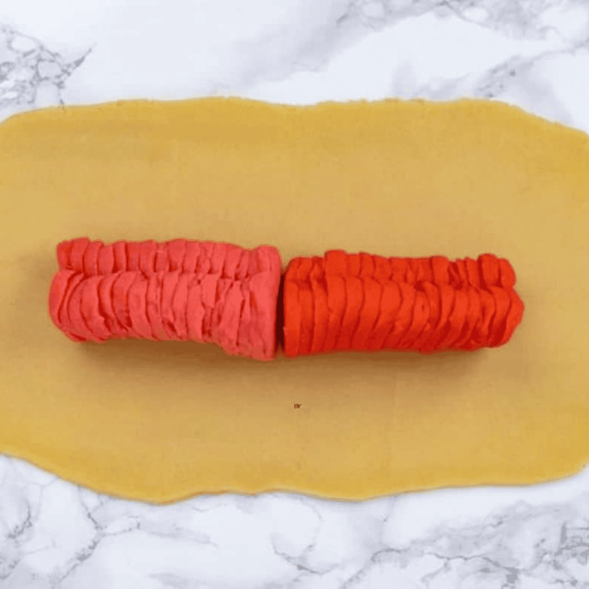 Slicing chilled dough into ½ inch pieces on parchment-lined air fryer basket.