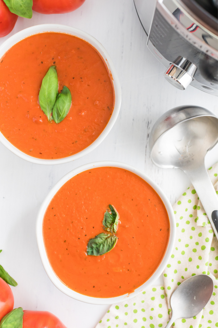 Bowl of creamy copycat Nordstrom tomato basil soup garnished with fresh basil leaves