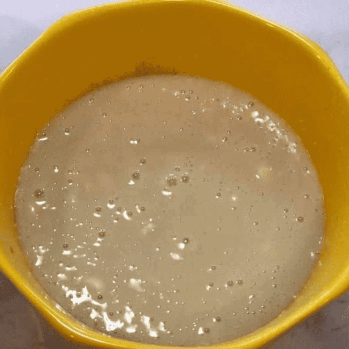 Canned peach slices arranged on cobbler batter in ramekins, ready to air fry.