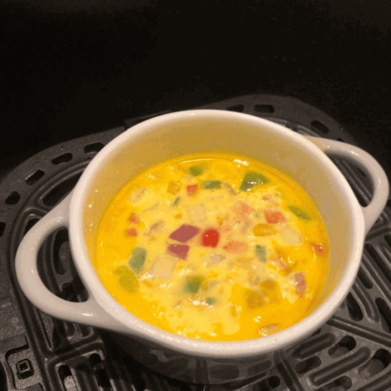 Cook omelet in air fryer at 350°F, topping with cheese.