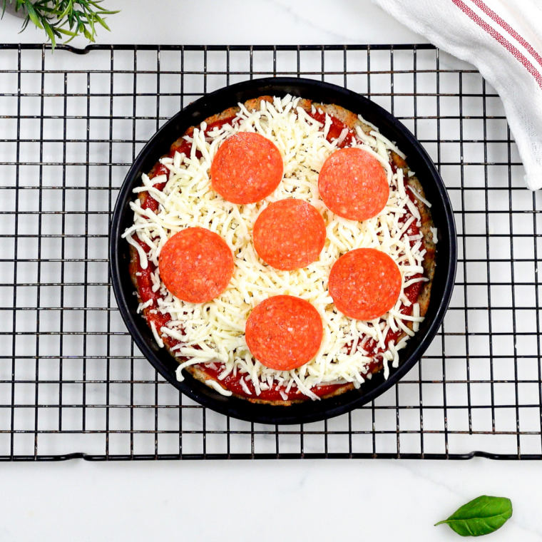 Par-baked pizza crust topped with shredded mozzarella and pepperoni before air frying