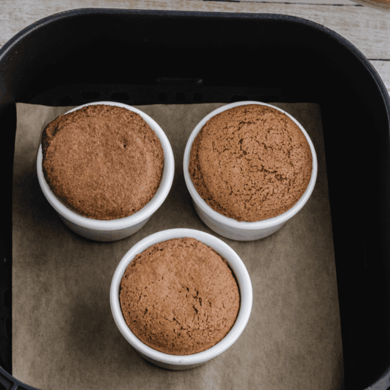 Air fryer apple pie mug cake in a ceramic mug with cinnamon apples on top