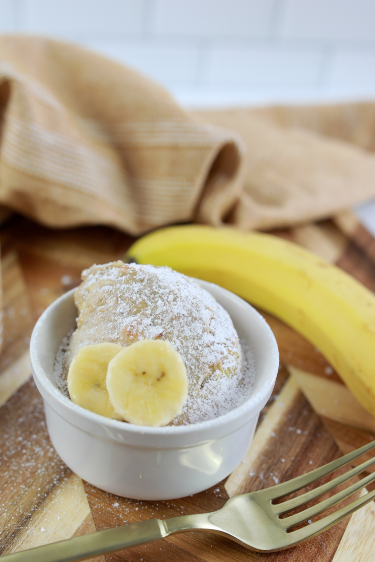 Close-up of air fryer banana bread mug cake topped with fresh banana slices