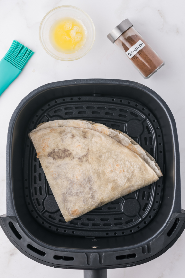 Folded banana Nutella quesadilla in an air fryer basket before cooking