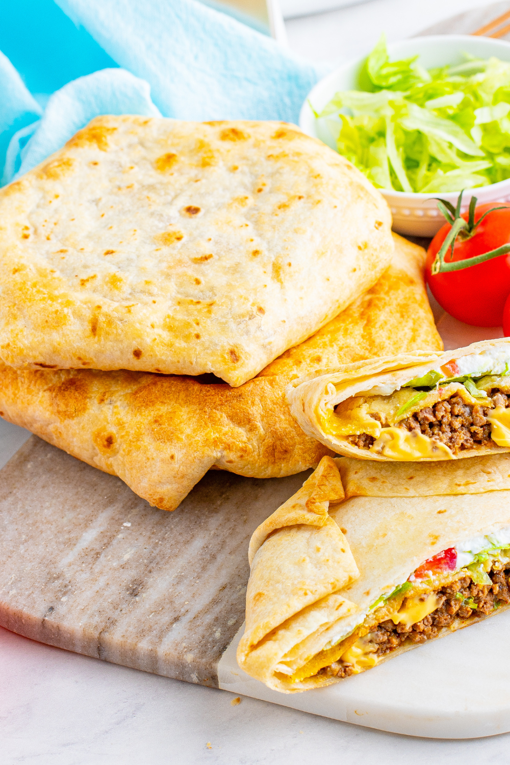 Close-up of crunchy folded tortilla wrap with seasoned beef, nacho cheese, and lettuce inside, air fryer crunchwrap.