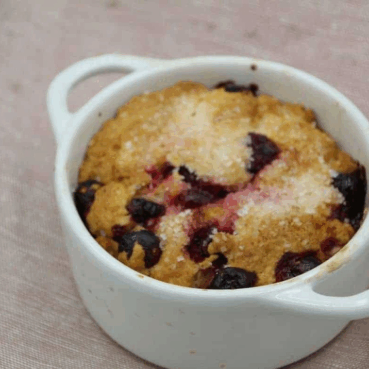 Air fryer cranberry breakfast cake sliced and served on a plate, showing a moist crumb with fresh cranberries.