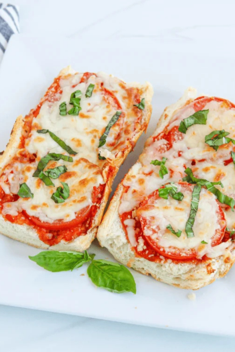 Cheesy air fryer French bread pizza with stretchy mozzarella and fresh basil garnish