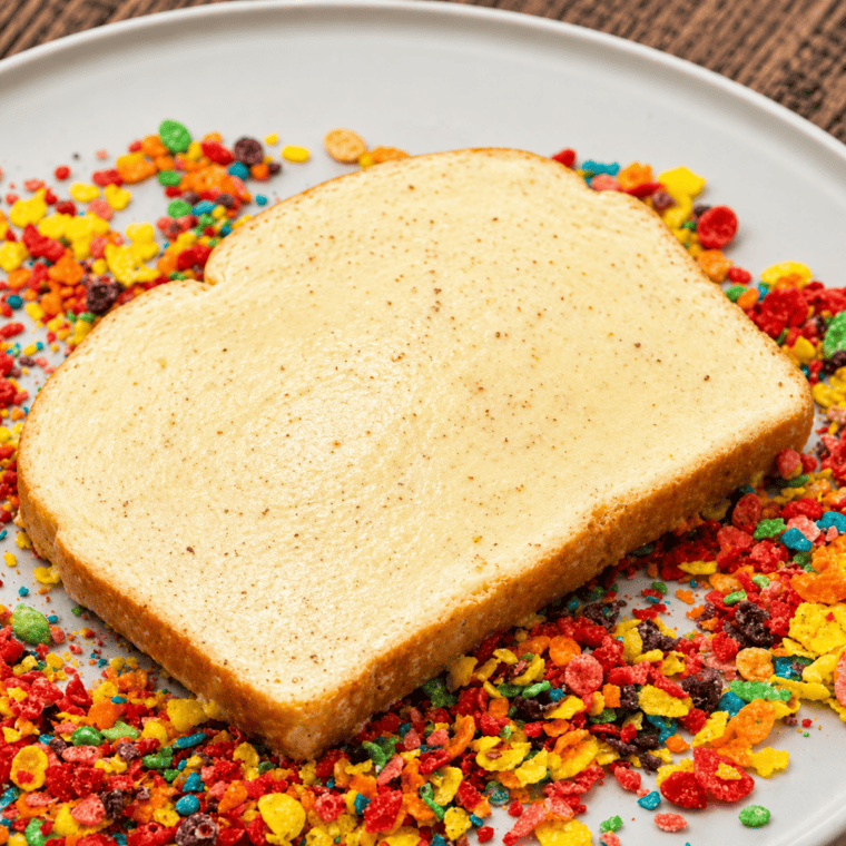 Pressing crushed Fruity Pebbles onto egg-soaked bread to coat both sides.