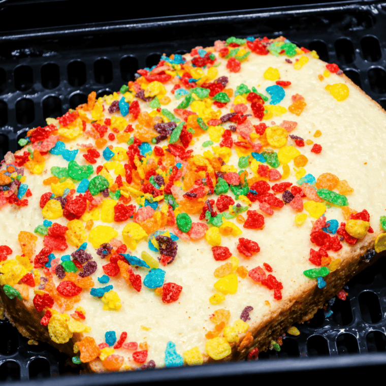 Fruity Pebbles French toast slices cooking in an air fryer basket.