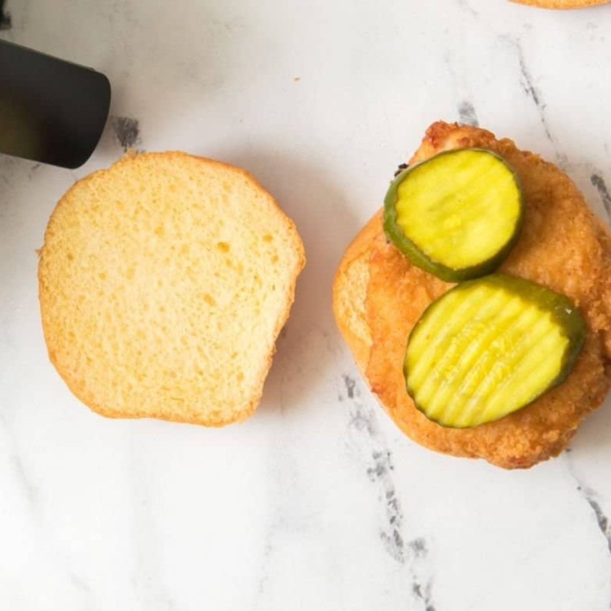 Plate of air fryer Aldi Red Bag Chicken sandwiches on brioche buns with dill pickles