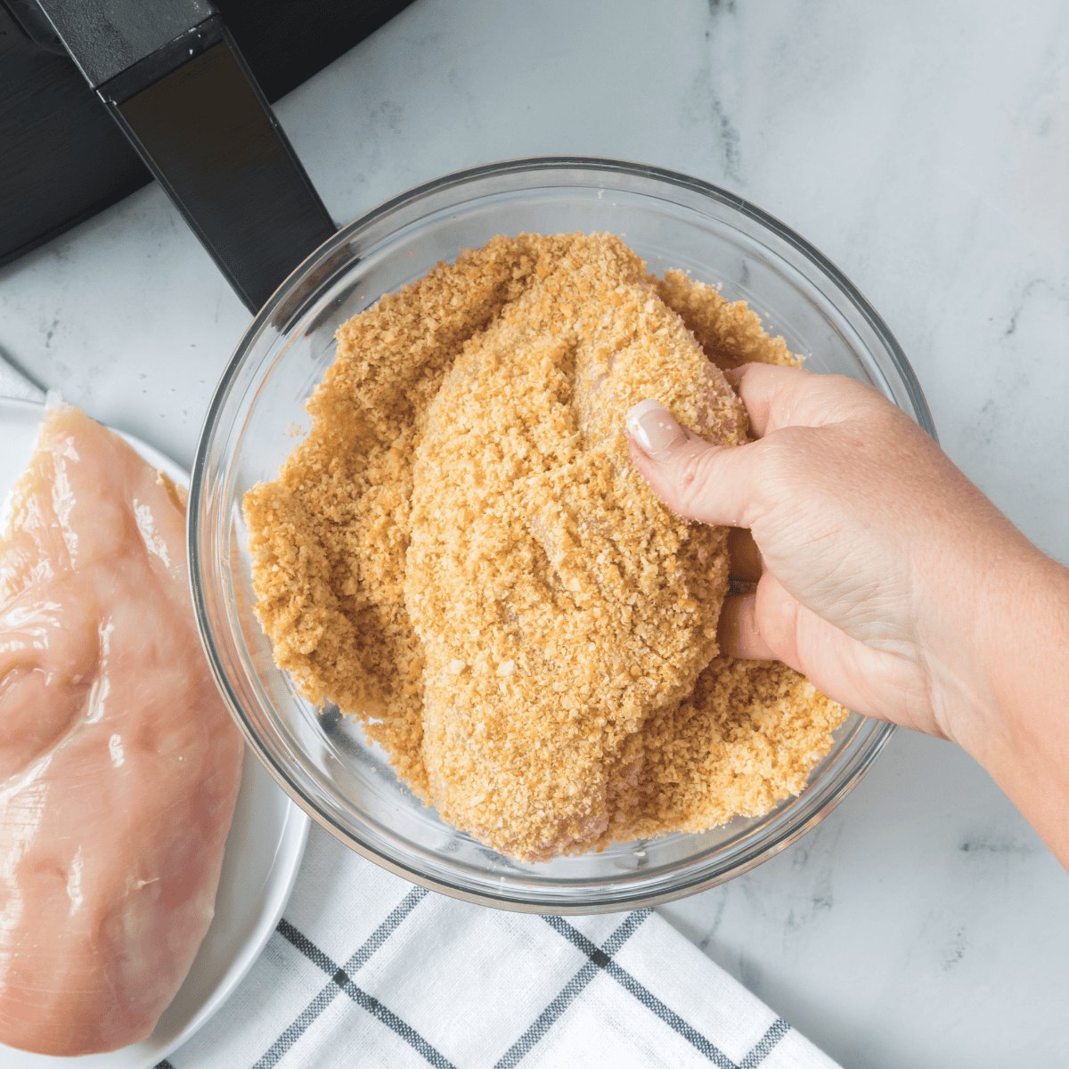 Chicken pieces tossed with mayonnaise in a bowl before coating with Shake 'n Bake