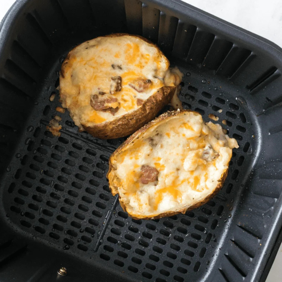 Air fryer twice baked potatoes with melted browned cheddar and chives on top