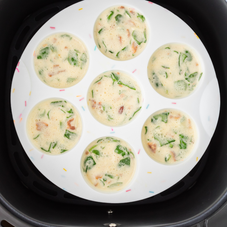 Egg mixture poured into greased silicone egg bite molds, each filled two-thirds full to leave room to rise