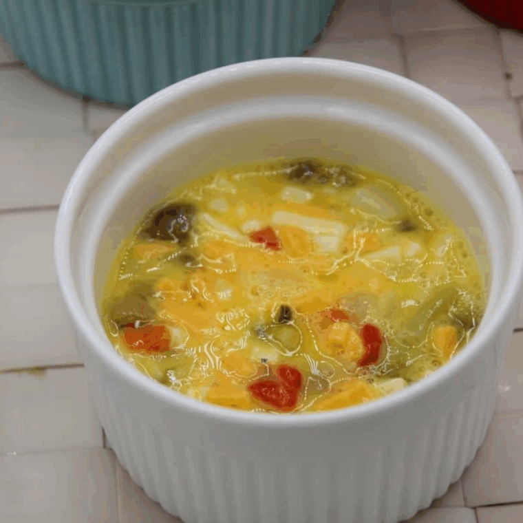 Ramekins filled two-thirds with egg mixture, sprayed with non-stick cooking spray, placed in air fryer at 320°F for 6-9 minutes.