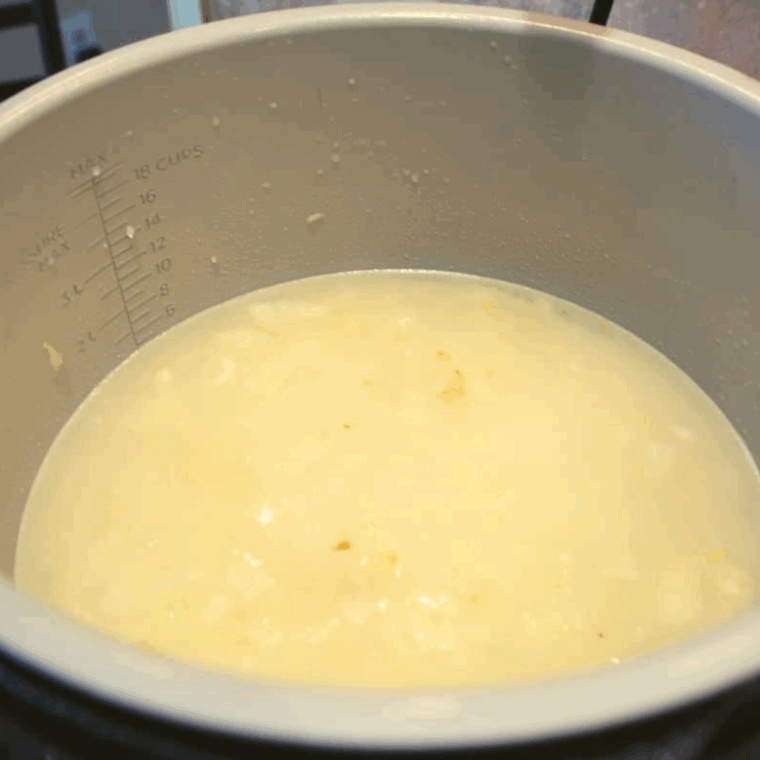 White wine, chicken broth, Parmesan, and seasonings added to sautéed rice mixture in the Ninja Foodi before pressure cooking.