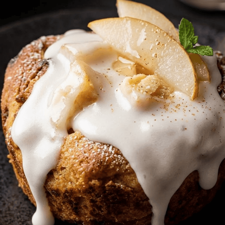 Baked apple pie cinnamon roll cups being drizzled with icing