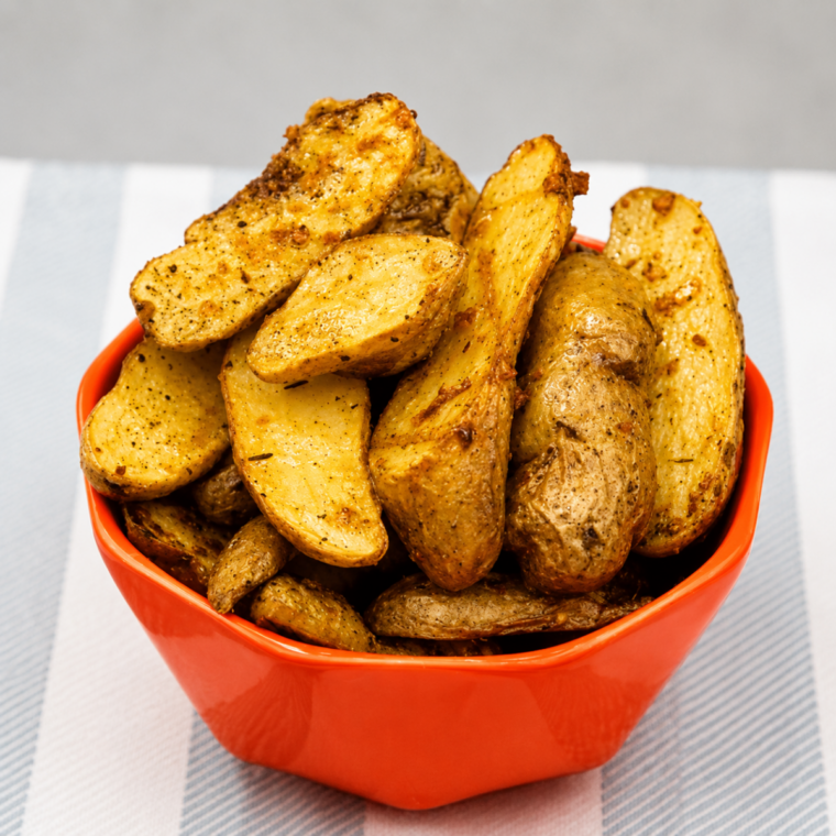 Finished air fryer garlic fingerling potatoes tossed with fresh parsley, cut sides deep golden