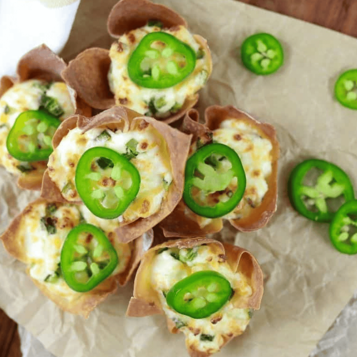 Air fryer jalapeno popper wonton cups stacked on parchment paper