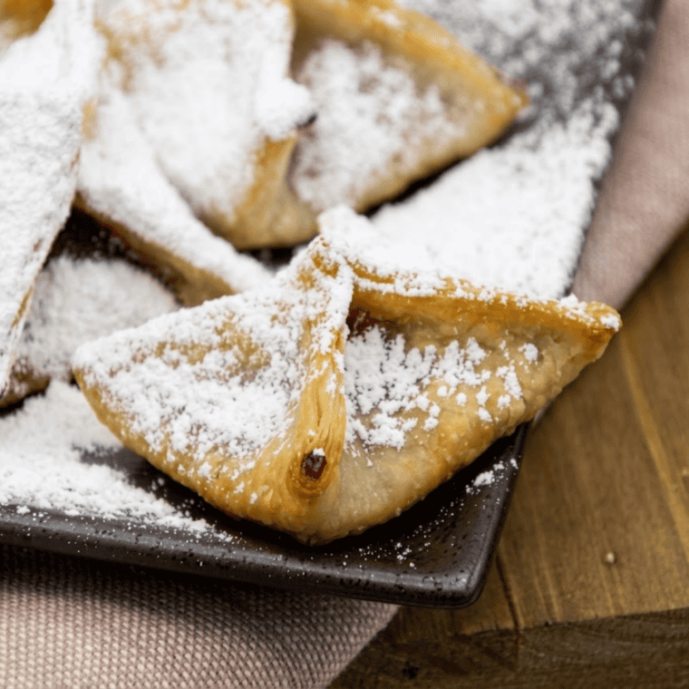Crispy air fryer raspberry wontons dusted with powdered sugar and filled with bright red raspberry filling.