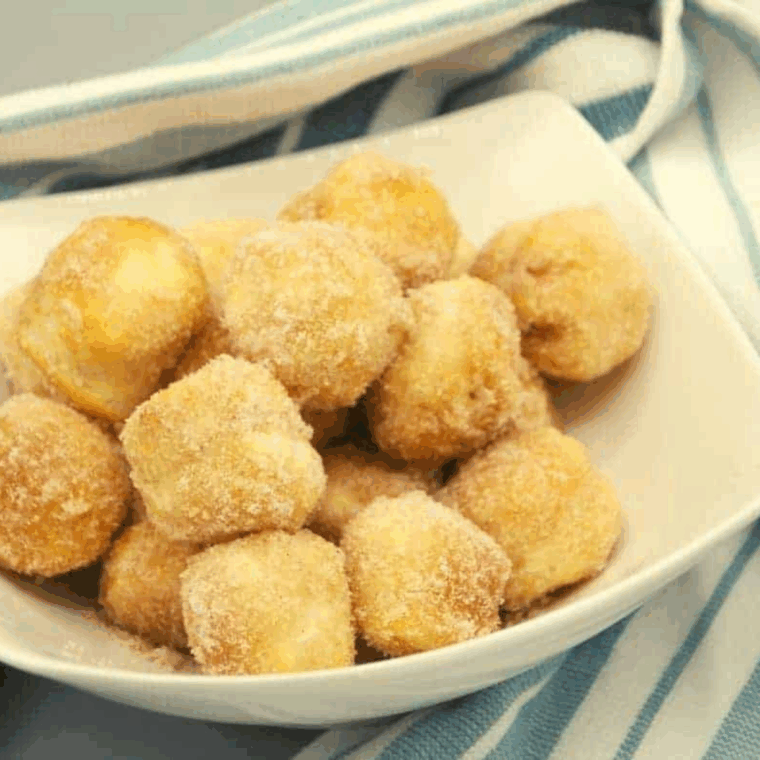 Golden, glazed Copycat Duck Donuts donut holes stacked on a plate, ready to enjoy.