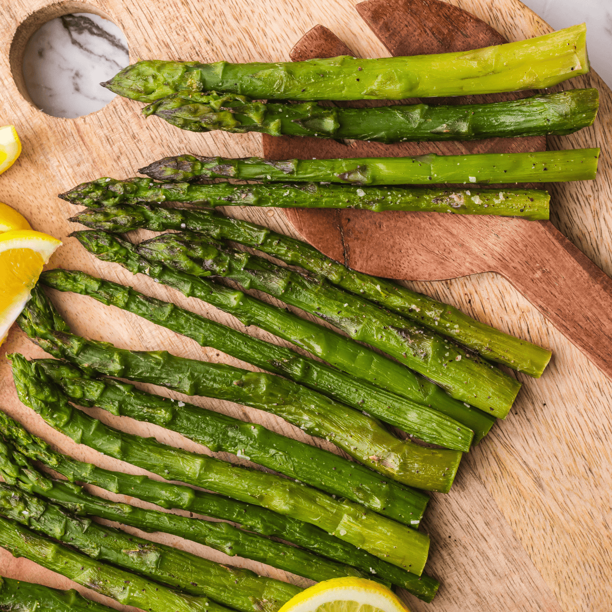 Frozen asparagus being cooked directly in an air fryer without thawing.