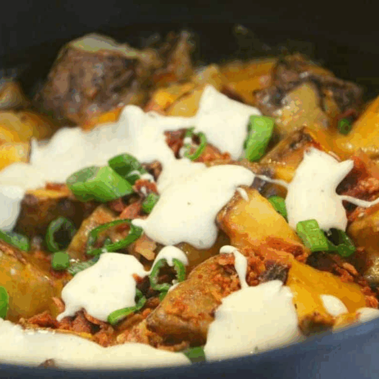 Loaded Ninja Foodi potatoes topped with melted cheese, bacon, and sour cream