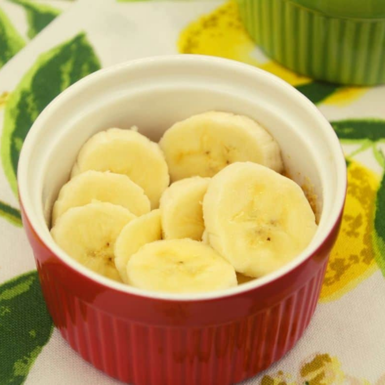 Sliced bananas layered in a single even layer over a graham cracker crust