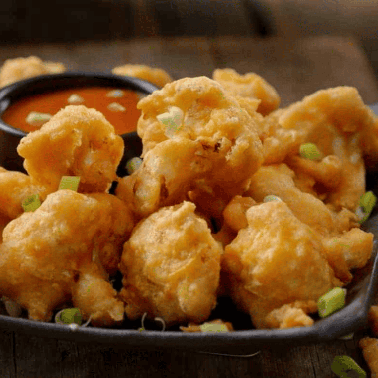 Crispy air fryer frozen battered cauliflower, golden brown and ready to serve.