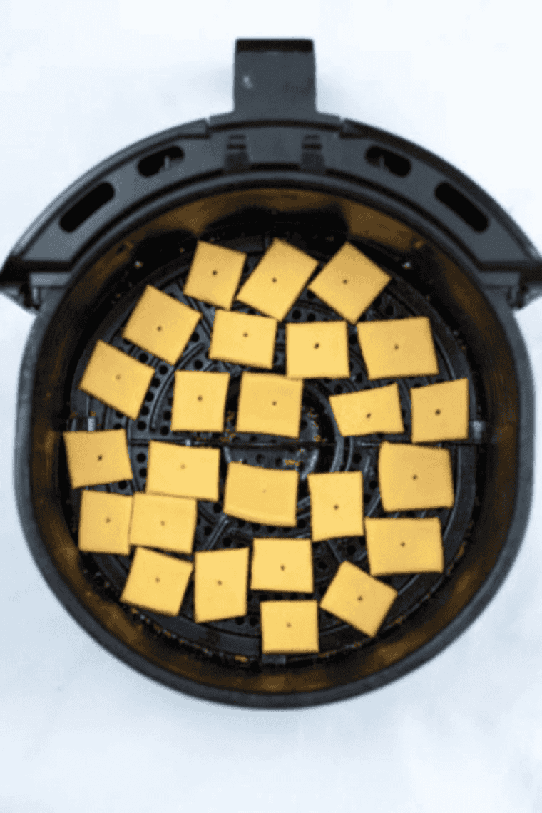 Cheez-It crackers arranged in a single layer in the air fryer basket
