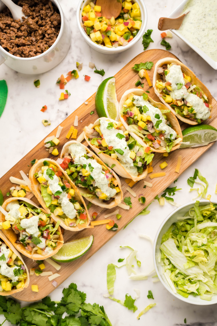 Air fryer mini taco boats topped with lettuce, pico de gallo, and cilantro-lime sour cream