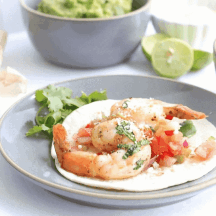 Air fryer shrimp fajitas with sautéed bell peppers and onions served on a plate.