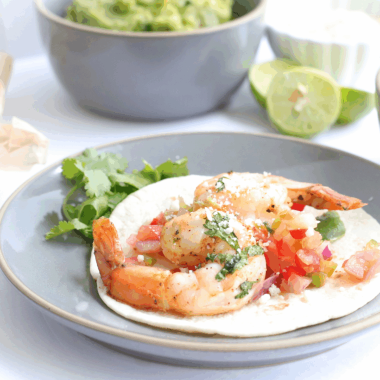 Air fryer shrimp fajitas with bell peppers and onions served on a plate.