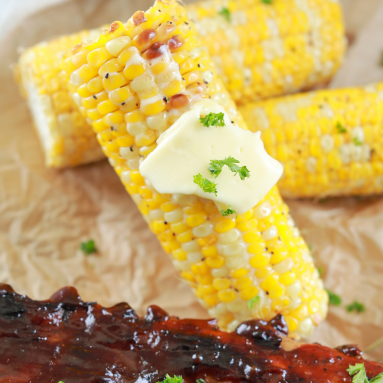 Grilled corn on the cob turning golden brown on a Blackstone outdoor griddle