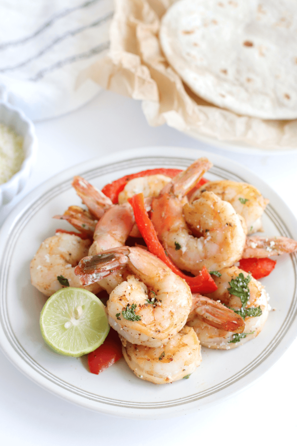 Air fryer shrimp fajitas with sautéed bell peppers and onions on a plate.