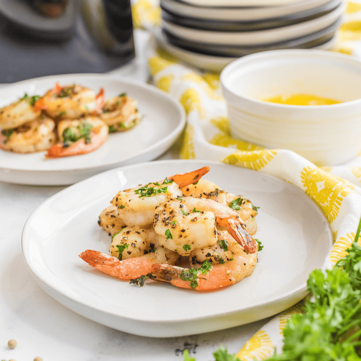 Crispy lemon pepper shrimp served on a plate with lemon slices and garnished with herbs.