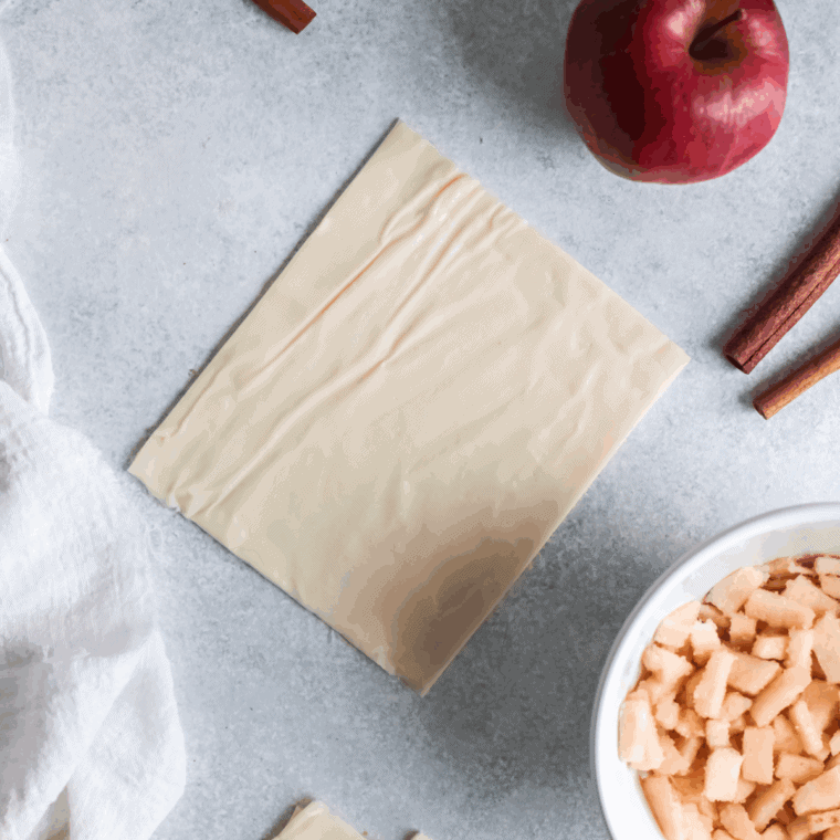 Puff pastry rolled out and cut into squares on a floured surface