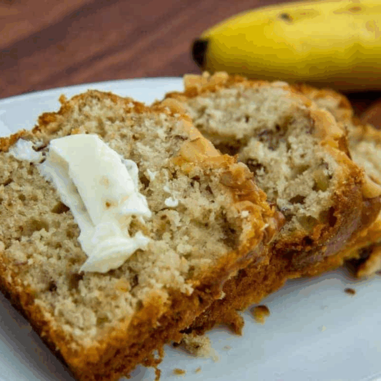 Air fryer banana walnut pound cake sliced with golden crust and walnuts.