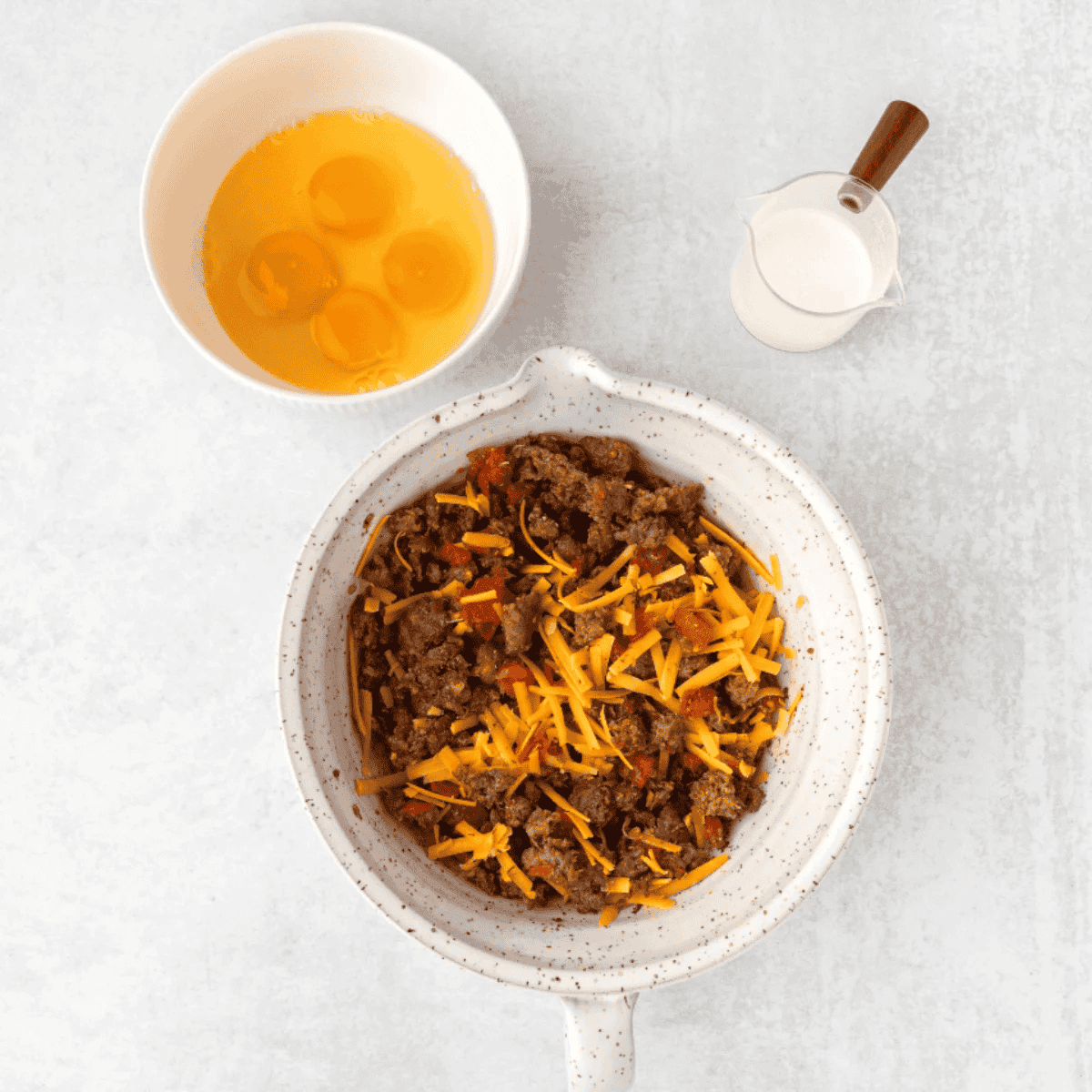 Preparing sausage, cheese, eggs and heavy cream for the air fryer egg casserole