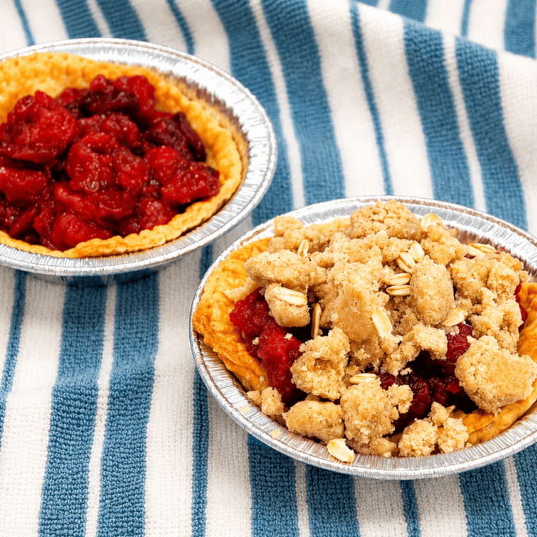Air fryer cherry crumb pies in the basket with golden crumble topping and bubbling cherry filling