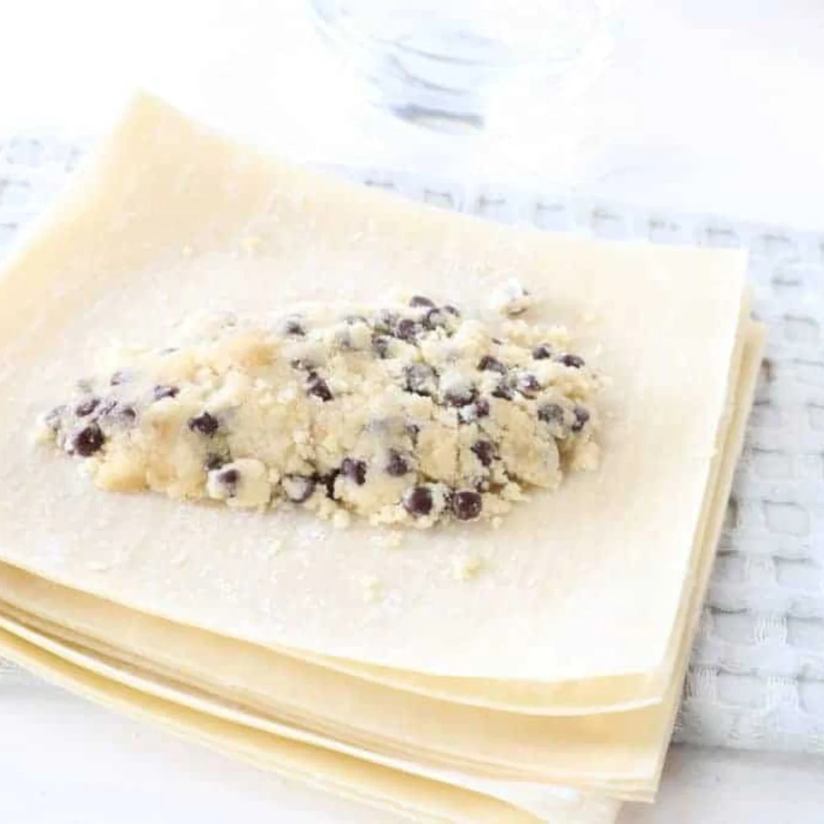 Two tablespoons of cookie dough shaped into a log in the center of an egg roll wrapper