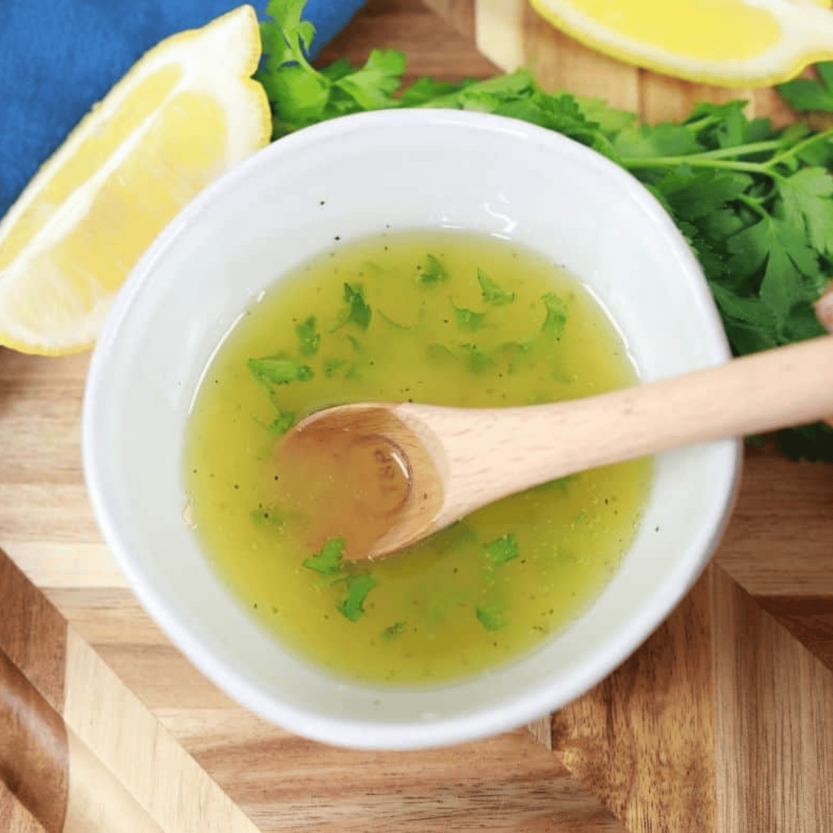 Scallops tossed in olive oil, lemon juice, and seasonings in a mixing bowl, evenly coated and ready for cooking.