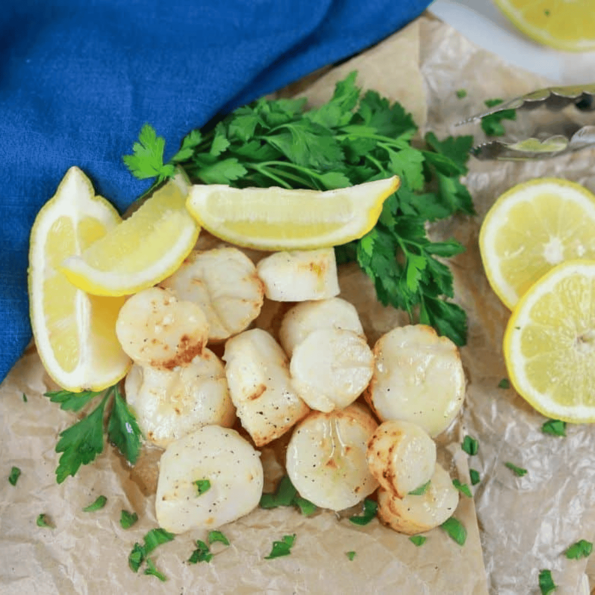 Golden, tender scallops cooked in garlic butter served on a plate, garnished with herbs.