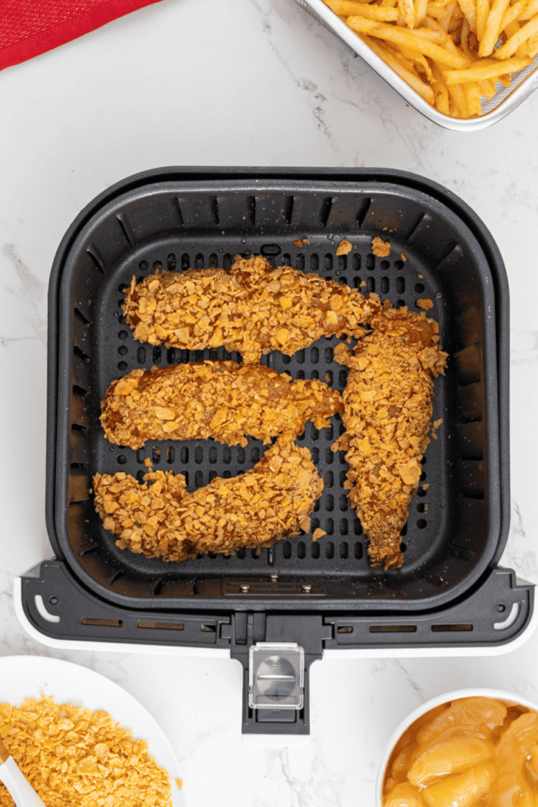 Air fryer preheating to 400°F with setup of dredging station including flour, beaten eggs, and seasoned panko breadcrumb mixture in separate dishes.