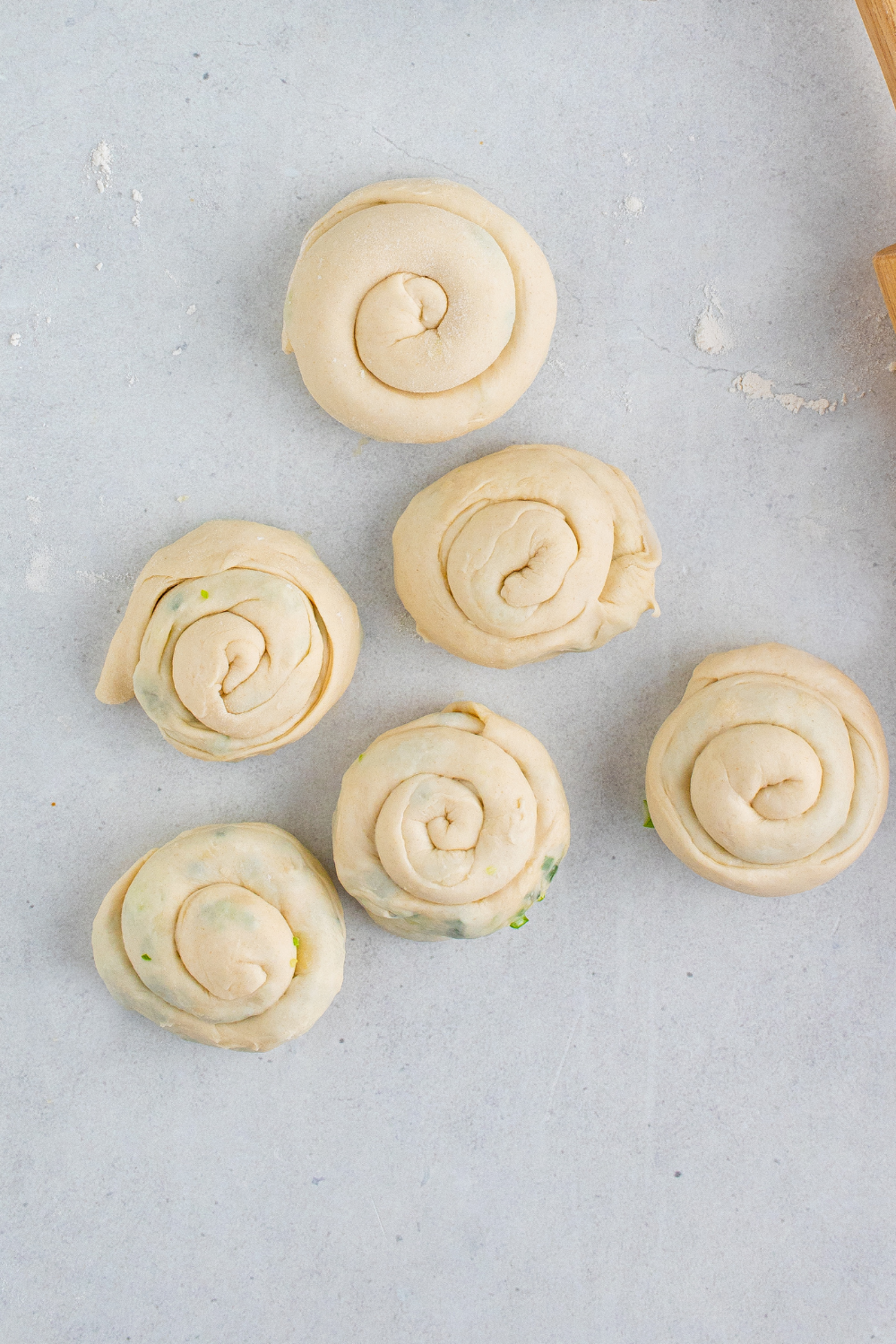 Rolled scallion pancake dough shaped into spiral coil