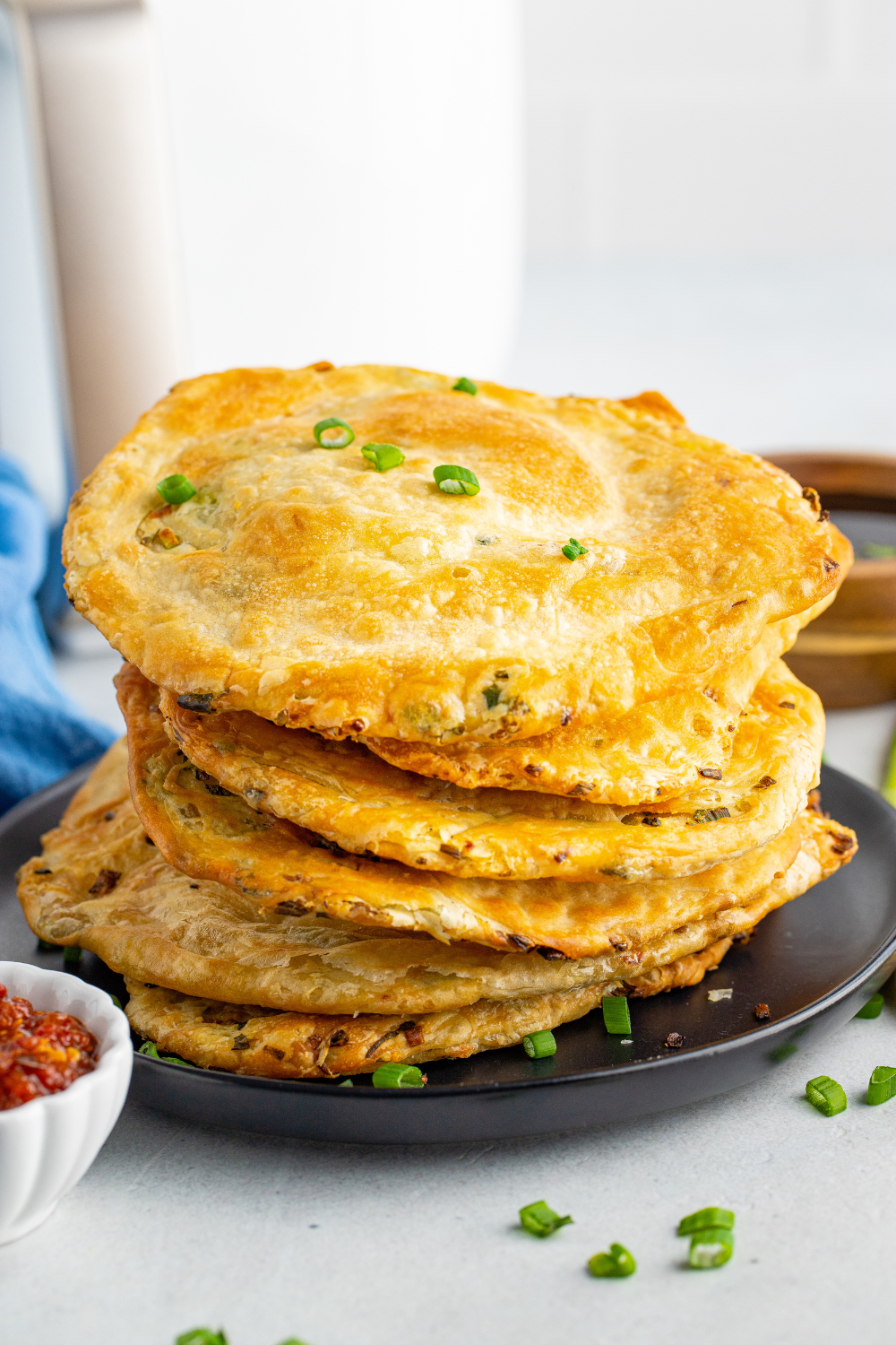 Scallion pancake cooking in air fryer basket until golden and crisp